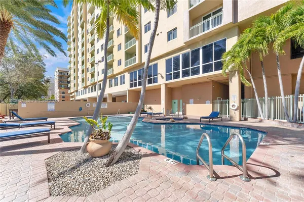 a view of a swimming pool with two chairs in a patio