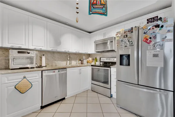 a kitchen with stainless steel appliances granite countertop a refrigerator and a stove