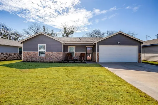 a front view of house with yard and garage
