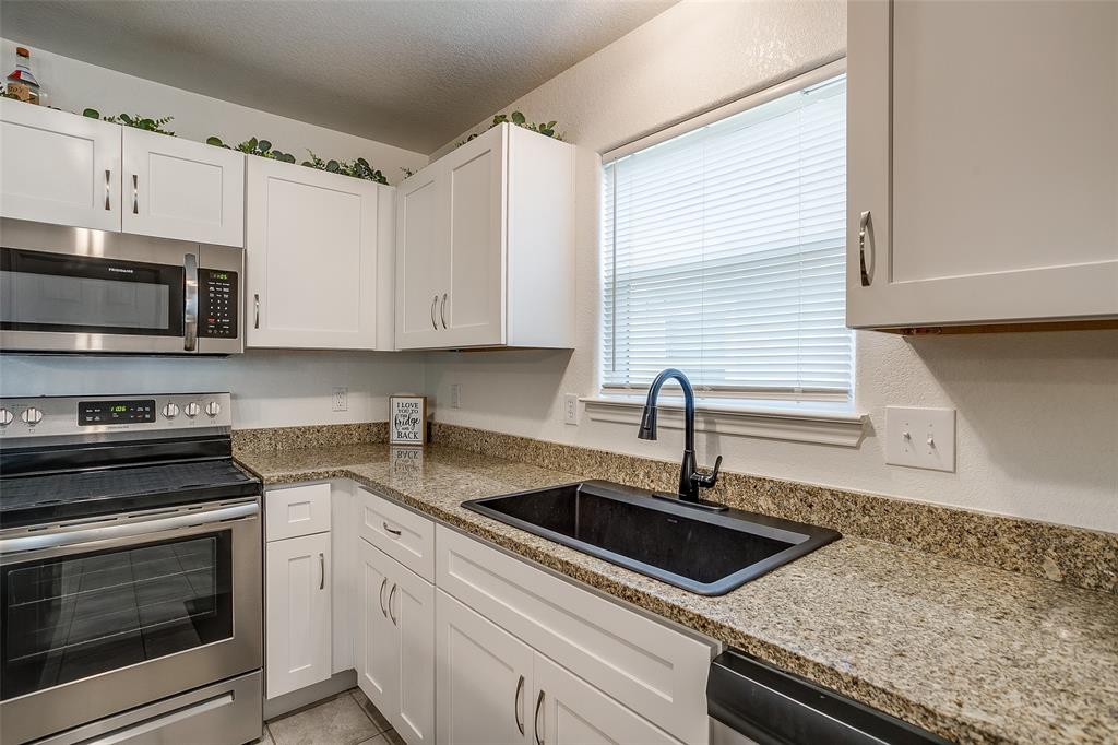 408 South Cleburne Whitney Road Rio Vista, TX 76093 - Photo 7 of 16 a kitchen with granite countertop a sink stainless steel appliances and cabinets