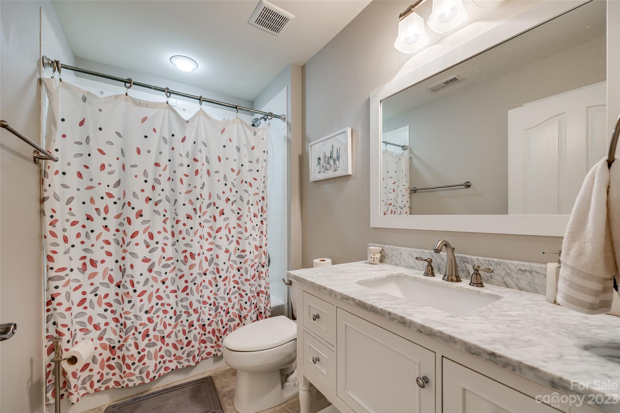 1055 Silver Gull Drive Tega Cay, SC 29708 - Photo 28 of 35 a bathroom with a granite countertop toilet a sink a mirror a shower and a sink