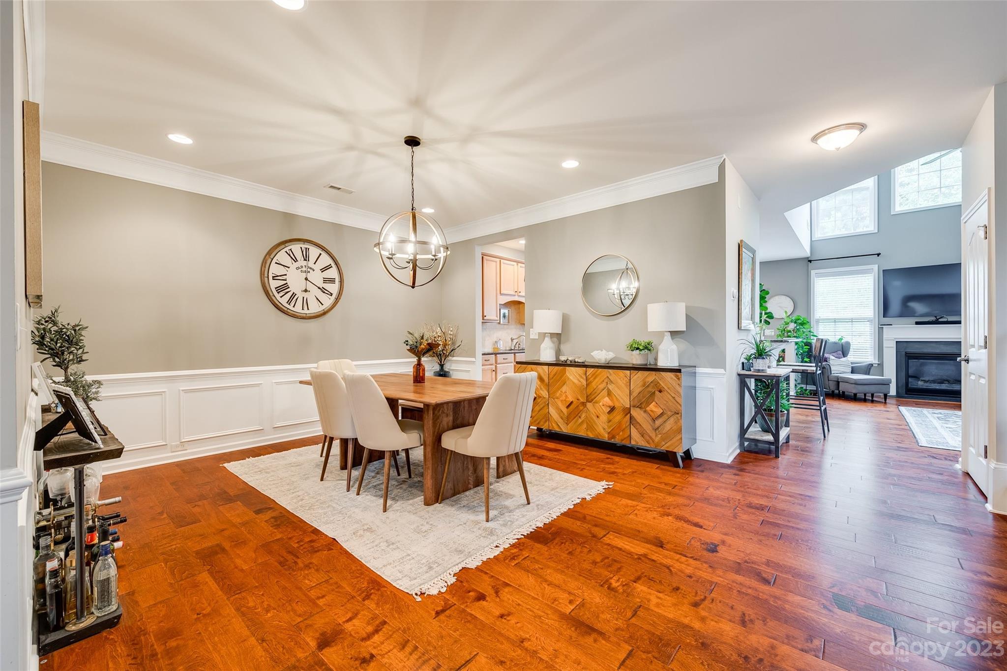 1055 Silver Gull Drive Tega Cay, SC 29708 - Photo 10 of 35 a view of a dining room and livingroom with furniture wooden floor a rug a painting and a chandelier