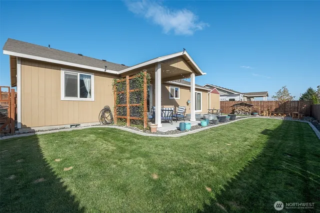 a backyard of a house with fountain table and chairs