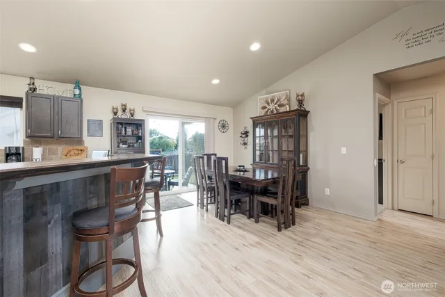 a living room with stainless steel appliances kitchen island granite countertop furniture and a wooden floor