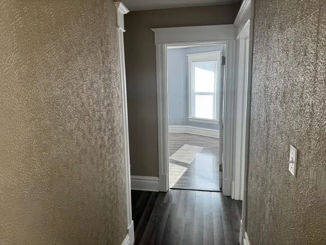 a view of a bathroom from a hallway with wooden floor