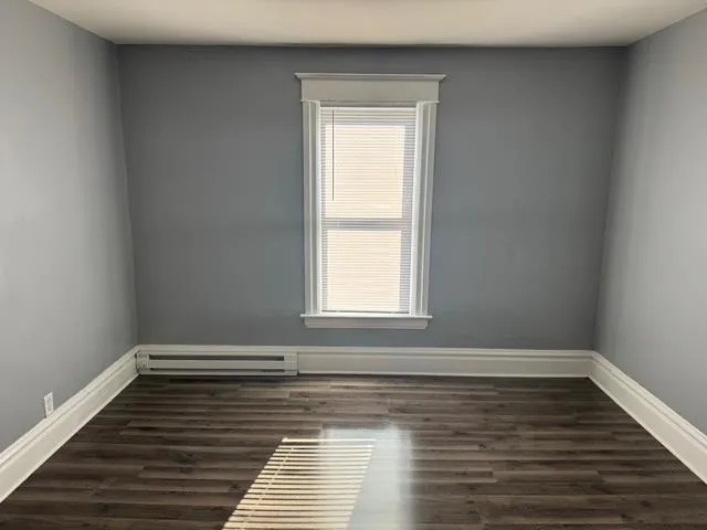 a view of a room with wooden floor and window