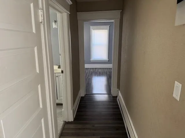 a view of a hallway with wooden floor