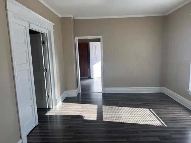 a view of empty room with wooden floor