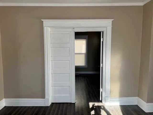 a view of a hallway with wooden floor and closet