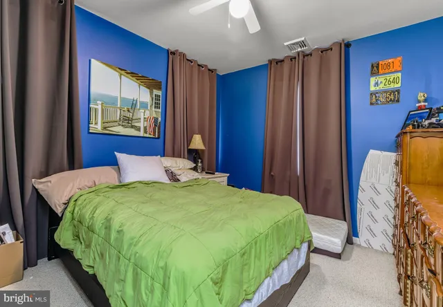 a bedroom with a bed and a painting on the wall