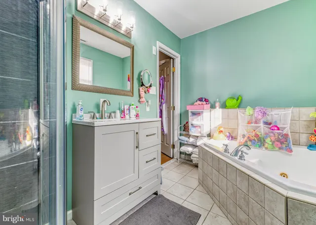 a bathroom with a sink mirror vanity and view of living room