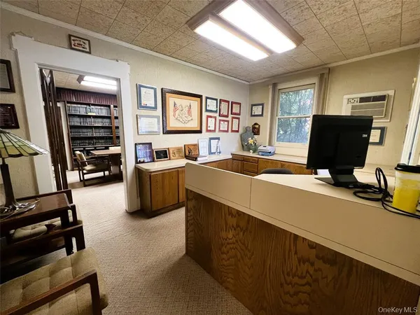a view of a livingroom with workspace and a window