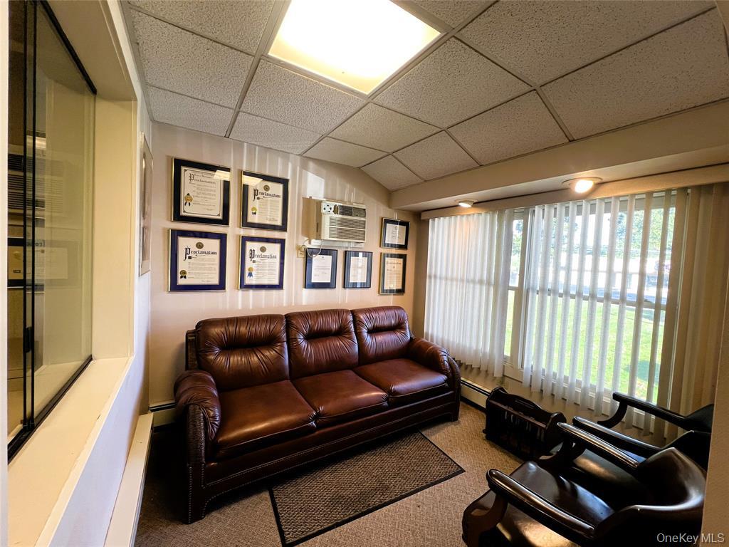 2566 Middle Country Road Centereach, NY 11720 - Photo 9 of 31 a living room with furniture gym equipment and a large window