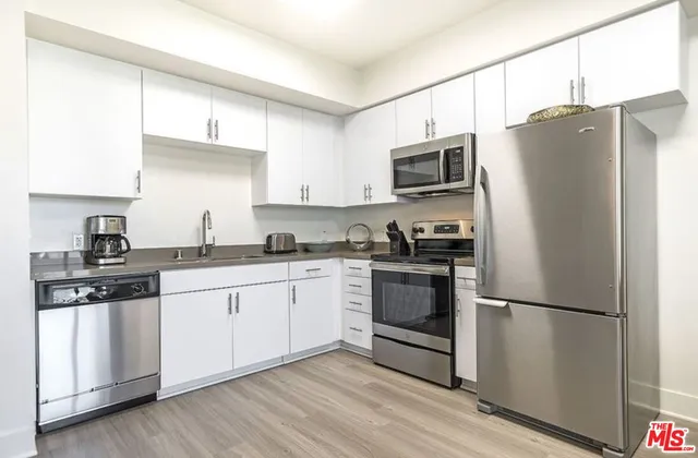 a kitchen with stainless steel appliances a refrigerator sink and microwave