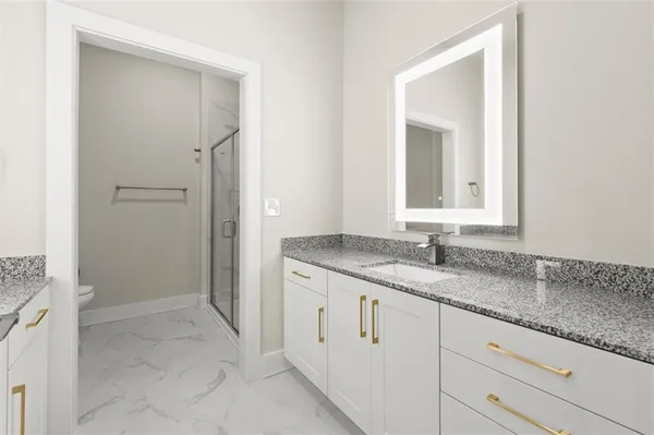 a bathroom with a granite countertop sink and a mirror