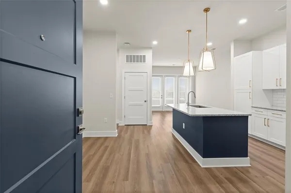 a large kitchen with a lot of counter space and wooden floor