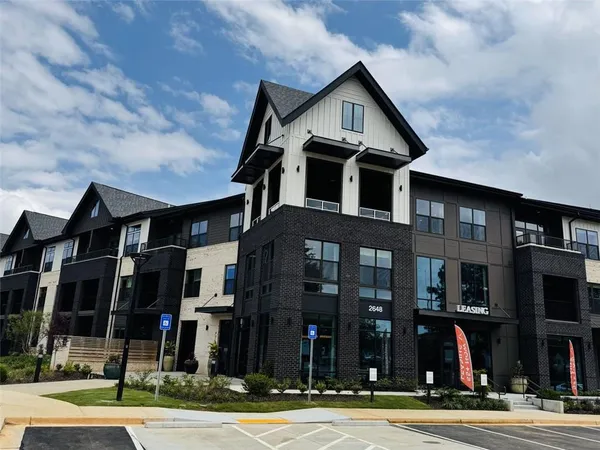 a front view of a residential apartment building with a yard