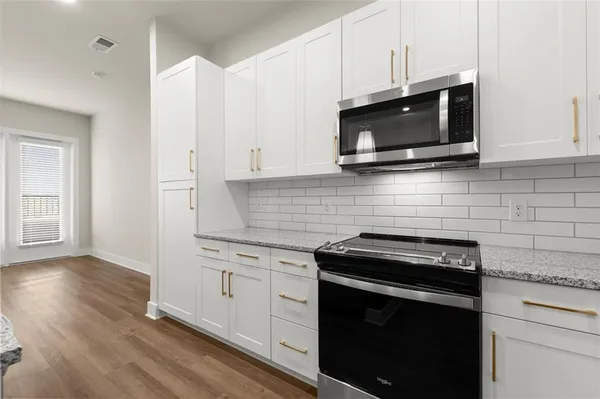 a kitchen with stainless steel appliances a stove microwave and sink