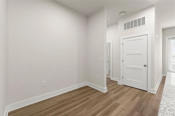 a view of an empty room with wooden floor