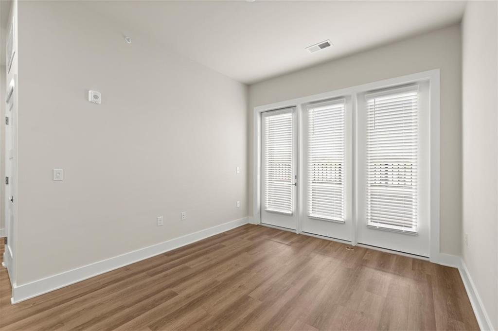 2648 Sandy Plains Road, Unit 424 Marietta, GA 30062 - Photo 9 of 33 an empty room with wooden floor and windows