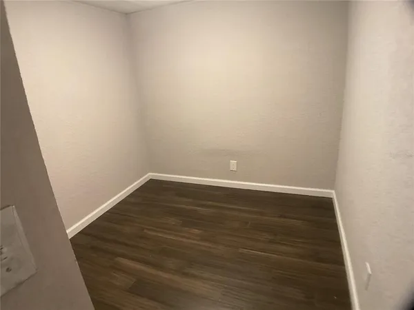 an empty room with wooden floor and a window
