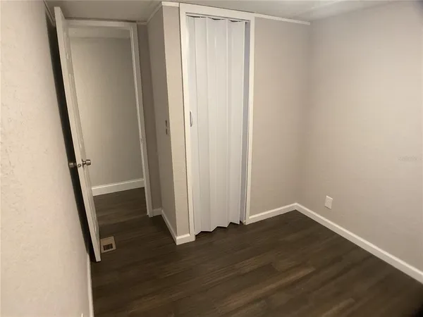 a view of an empty room with wooden floor