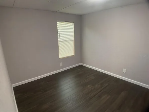 a view of an empty room with wooden floor