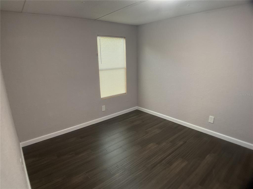 5038 Northeast Sandy Road Arcadia, FL 34266 - Photo 23 of 48 an empty room with wooden floor and a window