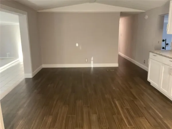 a kitchen with stainless steel appliances a sink a stove a refrigerator cabinets and a wooden floor