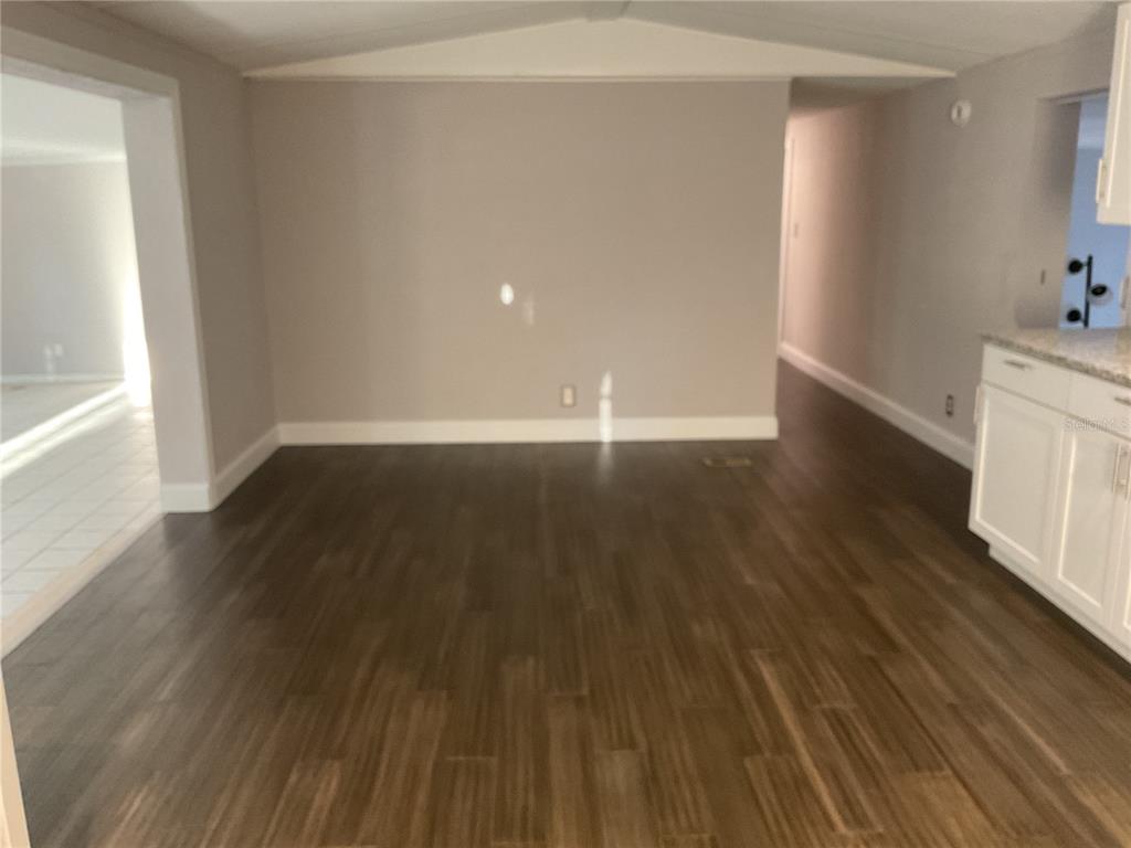 5038 Northeast Sandy Road Arcadia, FL 34266 - Photo 4 of 48 a view of an empty room with wooden floor and a window