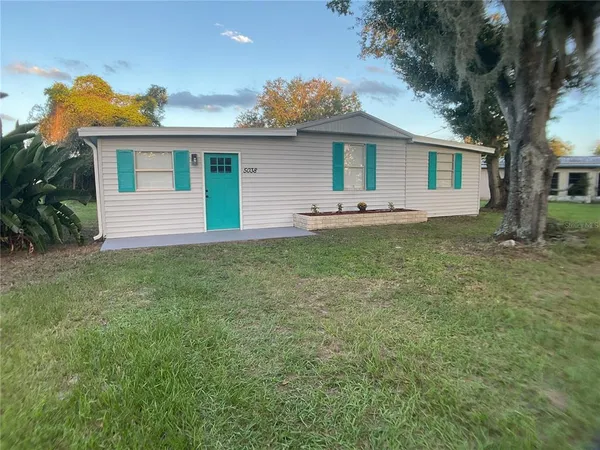 a front view of house with yard and trees