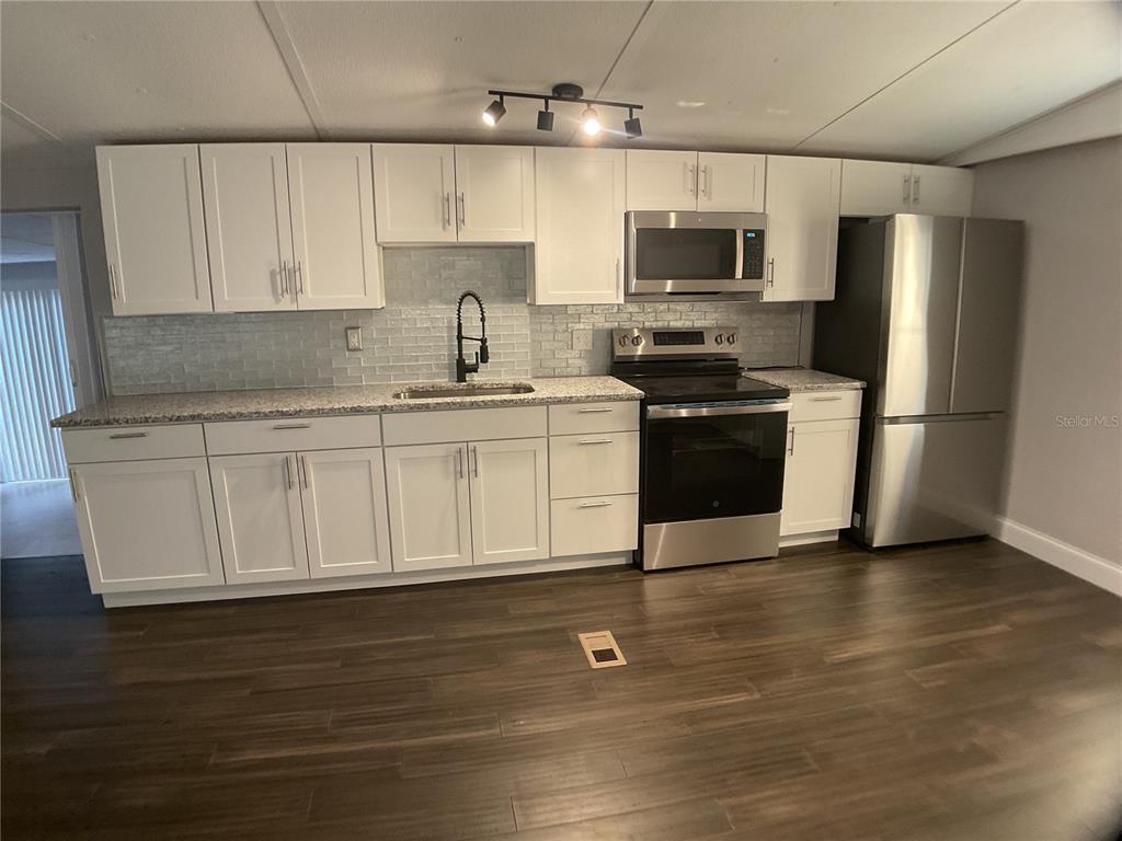 5038 Northeast Sandy Road Arcadia, FL 34266 - Photo 7 of 48 a kitchen with stainless steel appliances granite countertop a stove a sink and a refrigerator