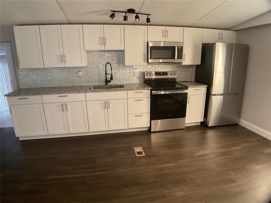 5038 Northeast Sandy Road Arcadia, FL 34266 - Photo 8 of 48 a kitchen with stainless steel appliances a refrigerator a stove a microwave and cabinets