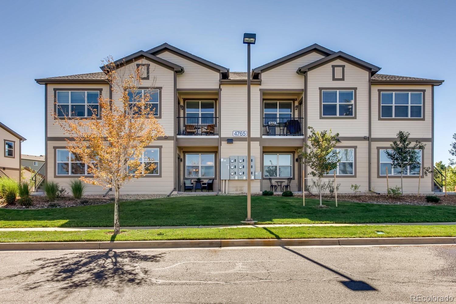 4765 Copeland Circle, Unit 103 Highlands Ranch, CO 80126 - Photo 1 of 28 a front view of a house with a yard and trees