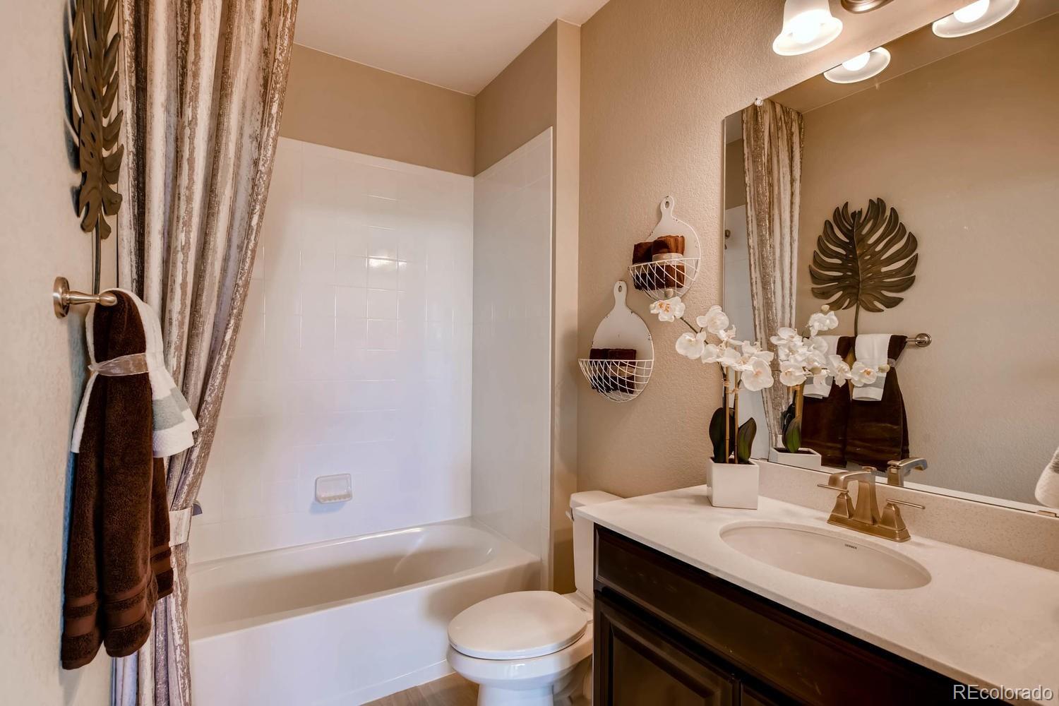 4765 Copeland Circle, Unit 103 Highlands Ranch, CO 80126 - Photo 20 of 28 a bathroom with a sink a toilet and shower
