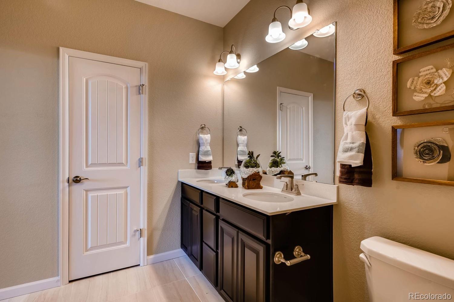 4765 Copeland Circle, Unit 103 Highlands Ranch, CO 80126 - Photo 24 of 28 a bathroom with a sink vanity and a mirror