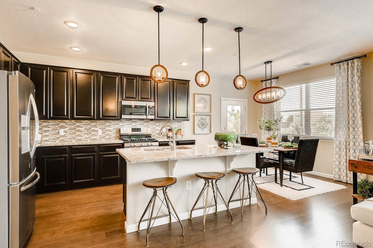 4765 Copeland Circle, Unit 103 Highlands Ranch, CO 80126 - Photo 5 of 28 a kitchen with stainless steel appliances granite countertop wooden floors sink and cabinets