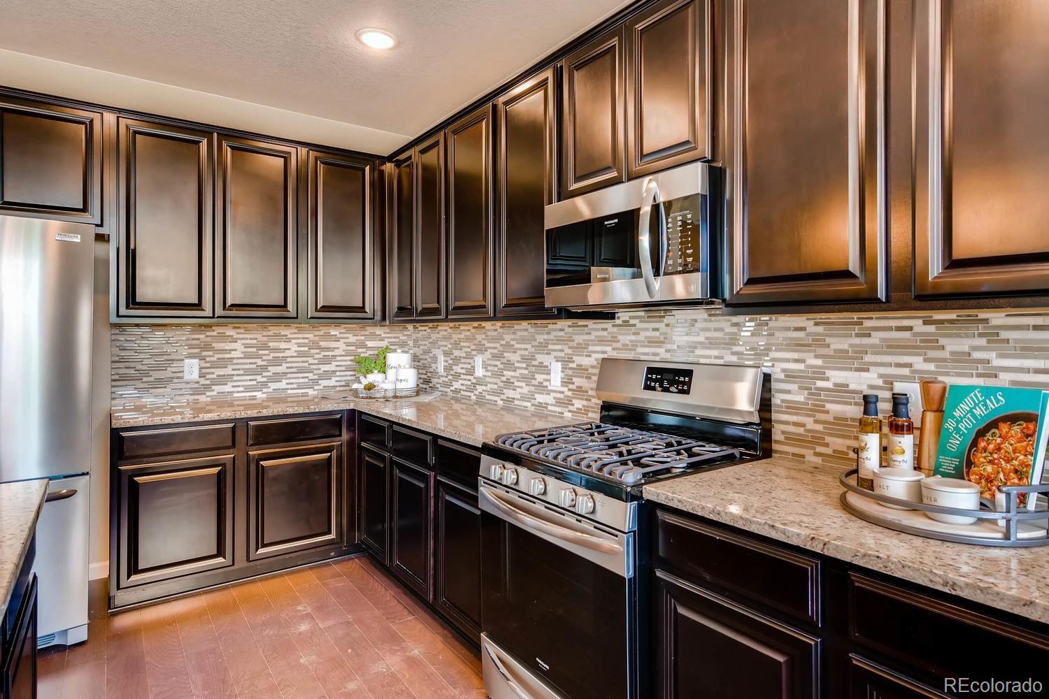 4765 Copeland Circle, Unit 103 Highlands Ranch, CO 80126 - Photo 7 of 28 a kitchen with stainless steel appliances granite countertop a stove a sink and a microwave