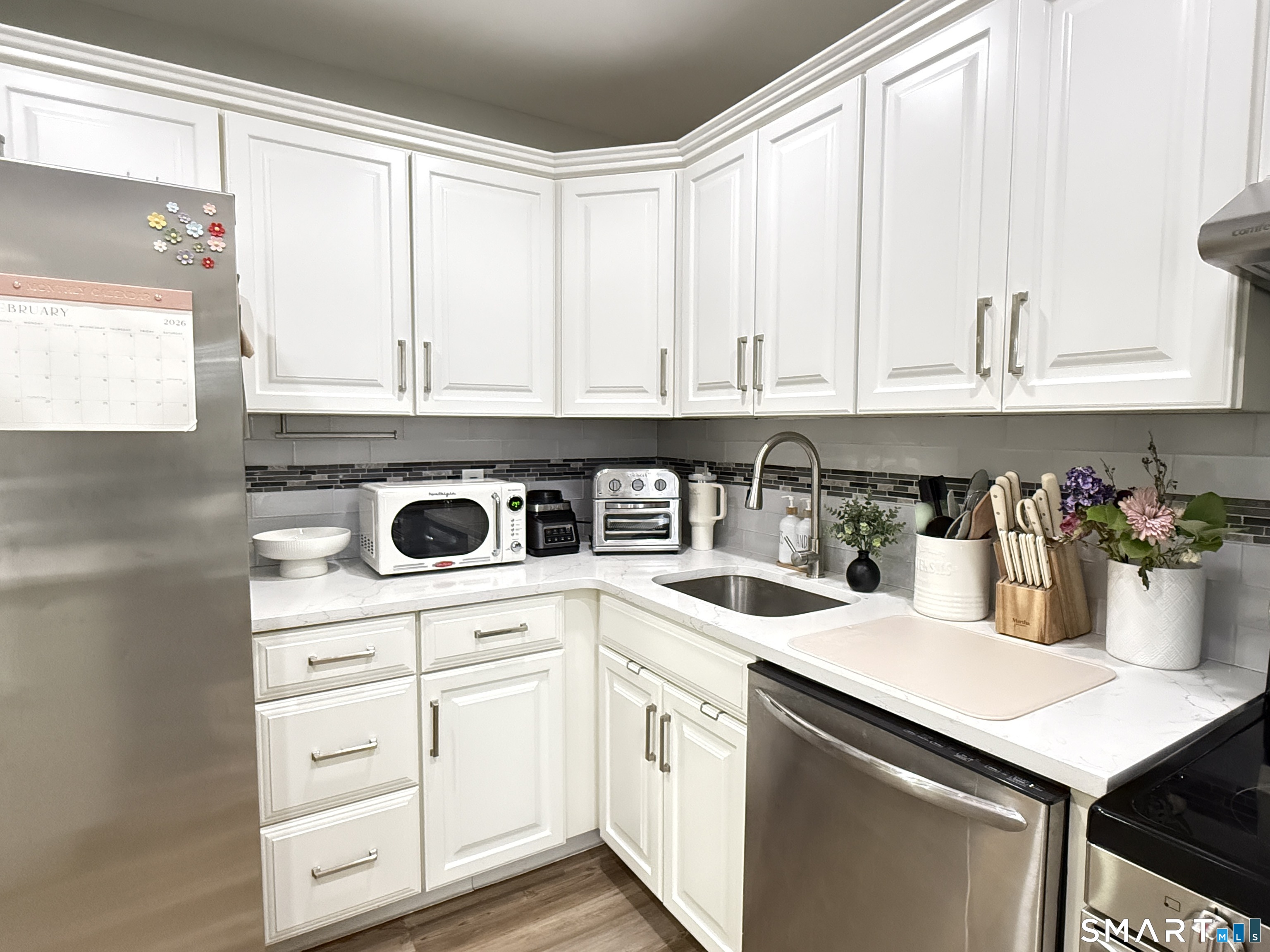 a kitchen with white cabinets and appliances