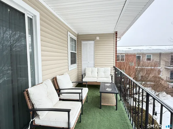 a balcony with wooden floor and furniture