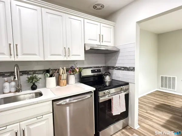 a kitchen with granite countertop white cabinets and white appliances