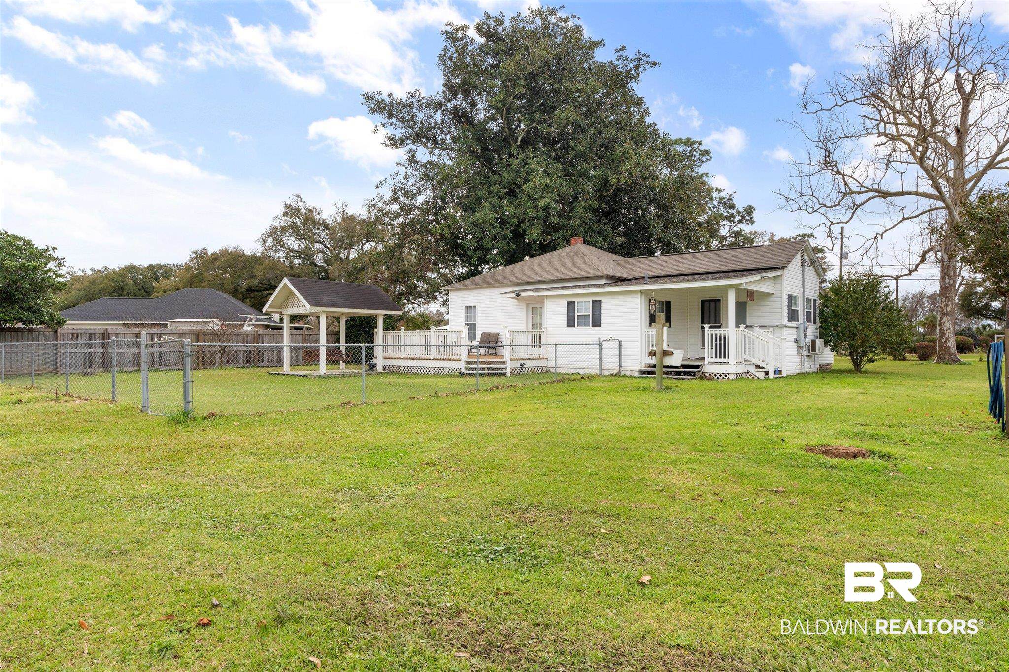 734 West Section Avenue Foley, AL 36535 - Photo 36 of 50 Back of property featuring a lawn, fence, and a chimney