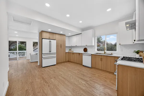 a kitchen with a refrigerator and a stove top oven