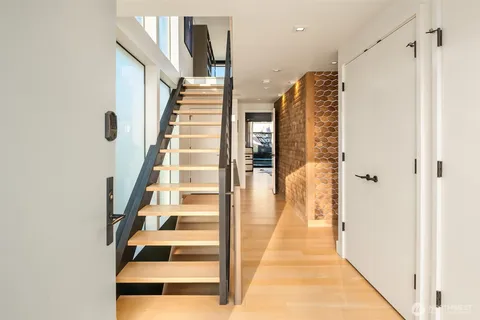 a view of a hallway with wooden floor and windows