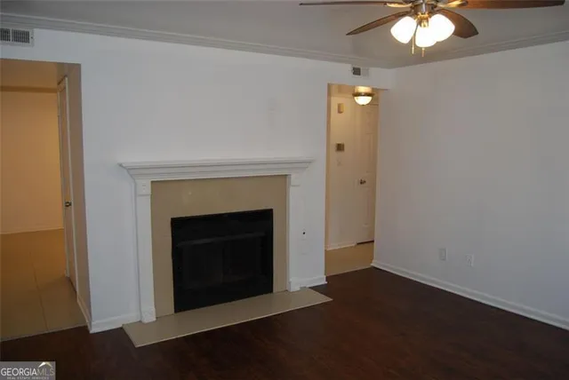 an empty room with a fireplace and chandelier fan