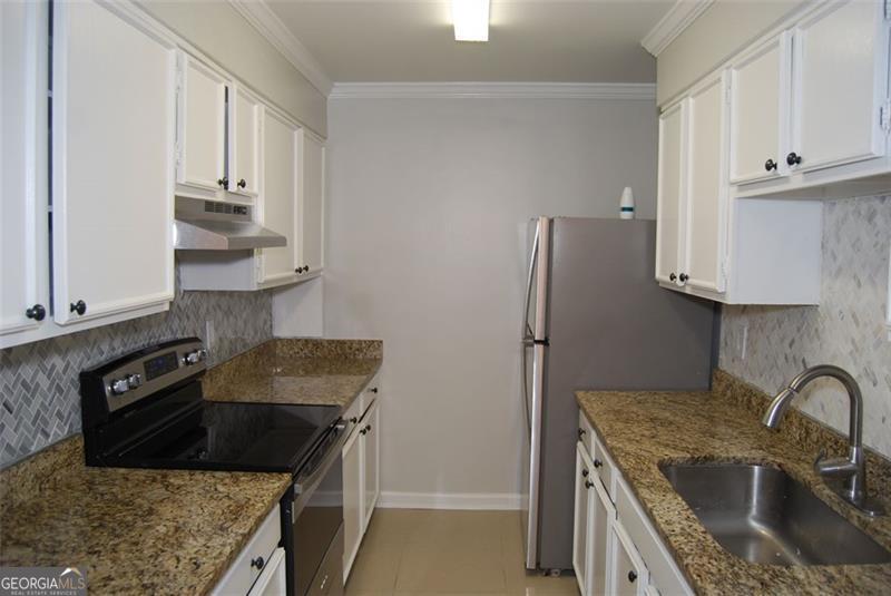 1166 Booth Road, Unit 903 Marietta, GA 30008 - Photo 5 of 15 a kitchen with stainless steel appliances granite countertop a sink stove and refrigerator