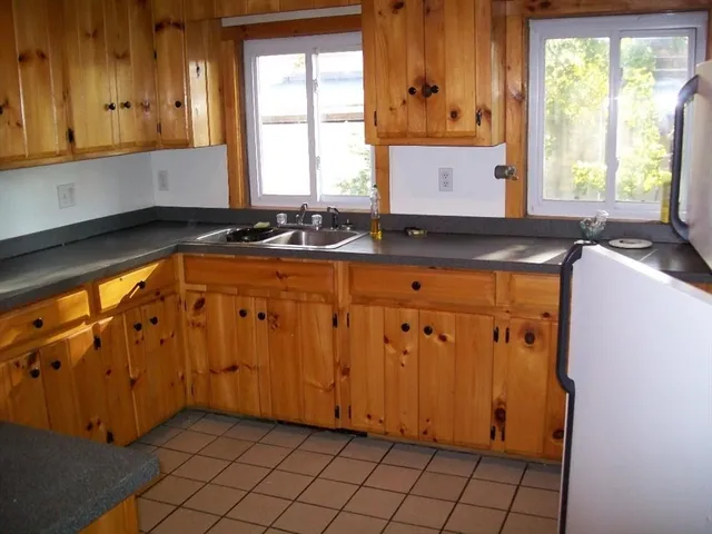 a kitchen with stainless steel appliances a sink window and cabinets