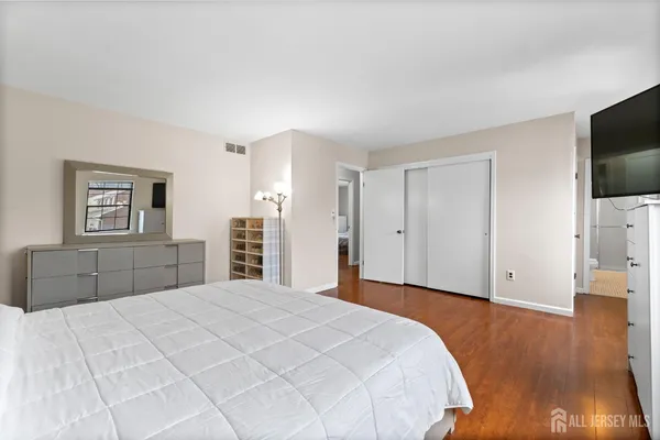 a bedroom with a bed and a flat screen tv