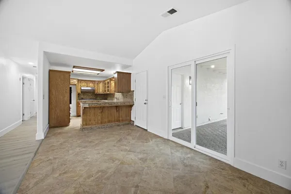 a view of a kitchen with refrigerator and wooden floor