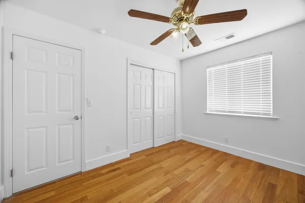 a view of empty room with wooden floor